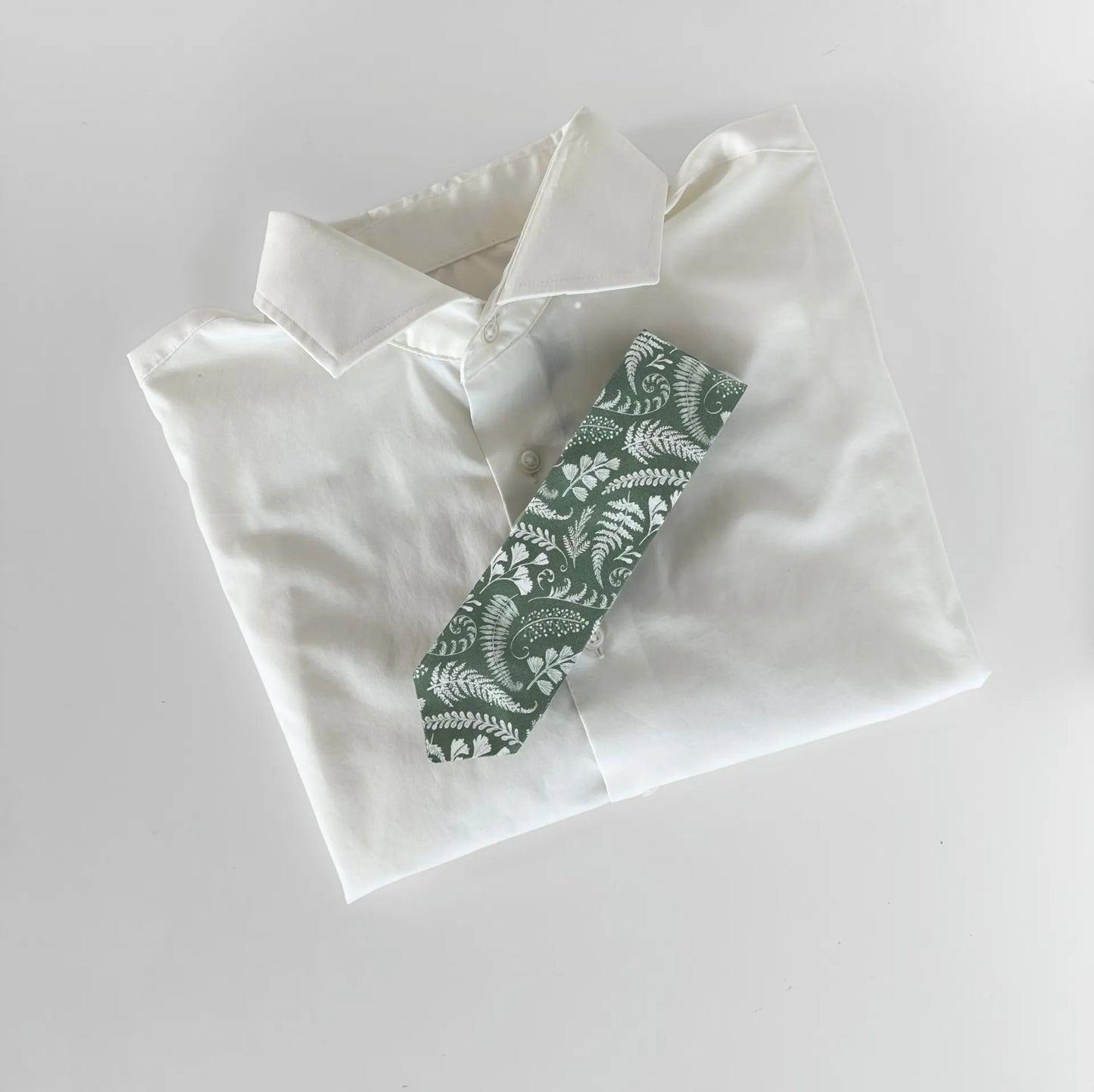 Canadian-made sage green tie featuring delicate white floral pattern, perfect for formal and casual occasions.